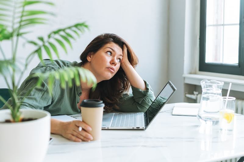 A woman at a table is distracted from her subcontracting work