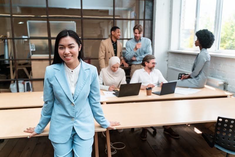 woman standing in a conference room with other freelance workers