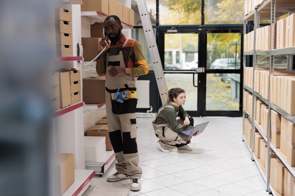 African american employee in Chicago discussing goods stock supply with warehouse supervisor in a popular role for temporary staffing near you.
