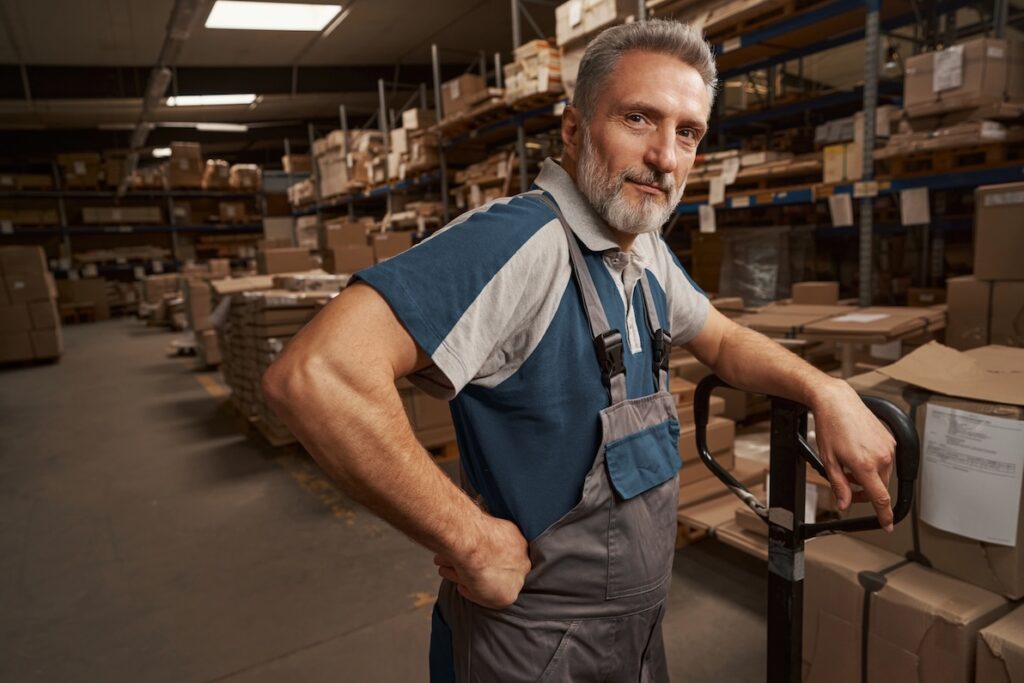 Cheerful male worker in Dallas leaning on a cart in a popular part time job near you.