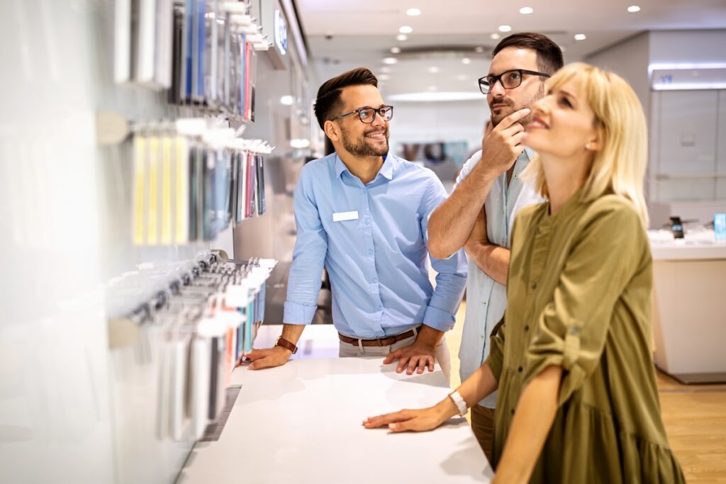 A young retail associate helps two customers in one of the best part time careers for learning about the world of business.