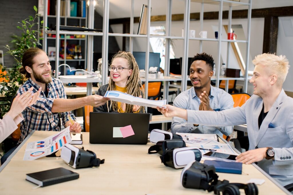 A group of young coworkers collaborate with high emotional intelligence in a diverse office.